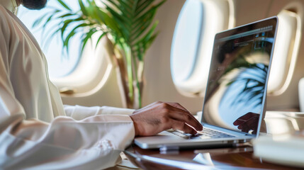 Muslim businessman in white traditional outfit working on laptop in the private jet during business trip. Generative AI
