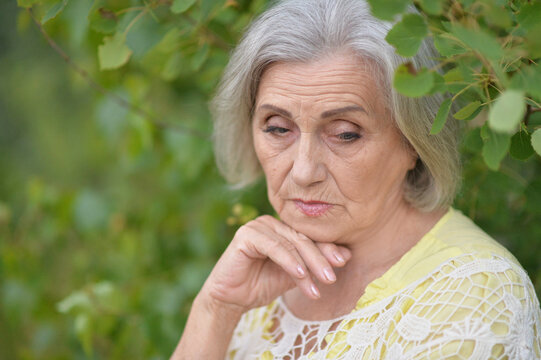 Portrait of sad seniour woman in park