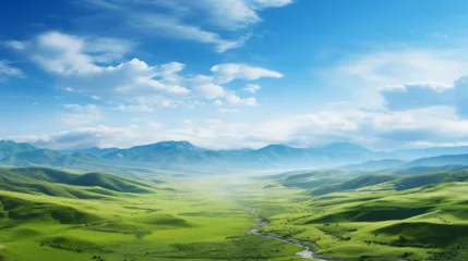 Foto op Canvas Paysage d'une prairie avec de l'herbe verte, des montagnes en arrière-plan et un beau ciel bleu avec nuages. Fond d'écran, décor, paysage calme. Pour conception et création graphique. © FlyStun