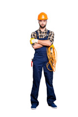 Full size body portrait of virile brutal electrician with bristle in overall, shirt, holding rolled...
