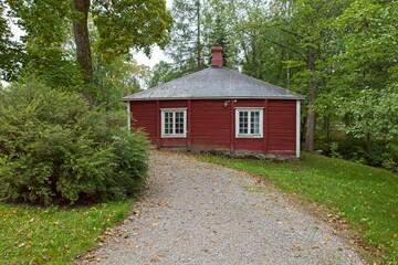 Old traditional style red wooden building in cloudy autumn weather, Finland.