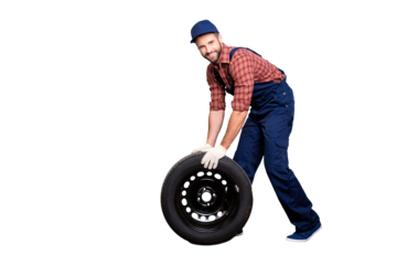 Full size body portrait with copy space of joyful attractive mechanic with stubble in blue overall, shirt, cap trundle tire looking at camera, isolated on grey background