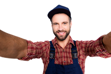 Self portrait of joyful cheerful mechanic with stubble in blue overall, shirt shooting selfie on front camera with two hands, isolated on grey background