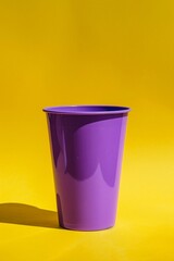A bold purple beverage cup on a sunny yellow background