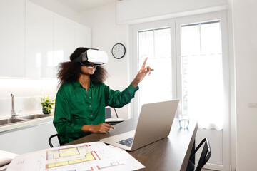 An African American woman with afro hairstyle is presenting home projects via virtual reality using...