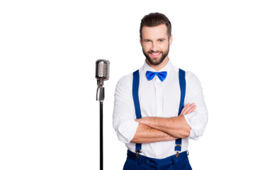 Portrait of famous joyful singer with bristle, wearing blue pants bowtie suspenders shirt, having his arms crossed, standing near mic isolated on grey background