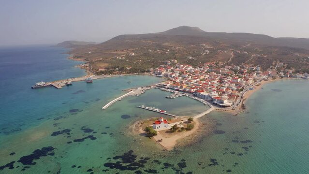 4k drone forward video (Ultra High Definition) of Saint Spiridon church and Elafonisos port on background. Morning seascape of Mediterranean Sea. Sunny outdoor scene of Elafonisos island, Greece.