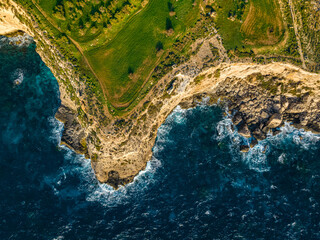 Aerial top view of green fields, cliffs and hills of Maltese island, nature landscape. Mediterranean sea