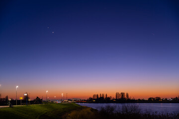 Jupiter and Saturn planets in the night sky appearing as a rare phenomenon at dusk during winter. The Great Conjunction an amazing and historical astronomical event at the end of day in Holland