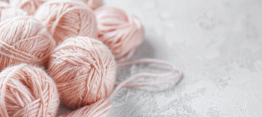 DIY knitting concept with decorative peach colored thread layout in the background - obrazy, fototapety, plakaty