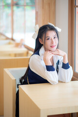 Cute woman with sweet smile sitting on chair, car, swing and looking aside while sitting in cafe. Happy woman walking in cafe in free time,resting in office cafe.Healthy lifestyle with woman laughing.