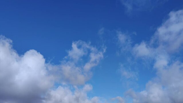 White cumulus cloud with plenty of light moves across the blue sky