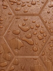 hexagonal pattern of water drops on a brown background