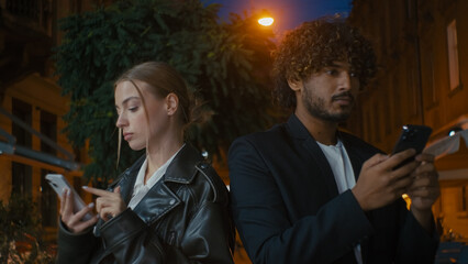 Couple man woman texting using smartphone mobile phone cellphone chat city outside street ignorance concentration separation busy addict frustrated boyfriend girlfriend gadget modern social media web