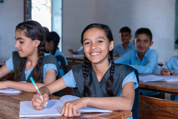 Group of indian village students in school uniform sitting in classroom studying. Selective Focus, Education concept