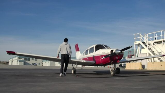 Low Angle Wide Shot of a Pilot Fueling a Piper Warrior Plane SLOMO