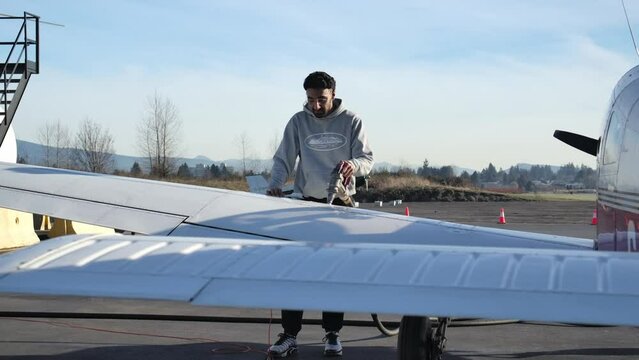 Male Persian Pilot Fuels Light Single Engine Airplane, Sunny Day SLOMO