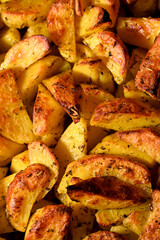 Close-up of Crispy potato wedges baked with seasonings.