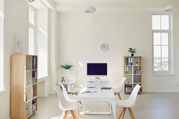 Modern office interior with white table, stylish chairs and desktop computer ready for corporate...