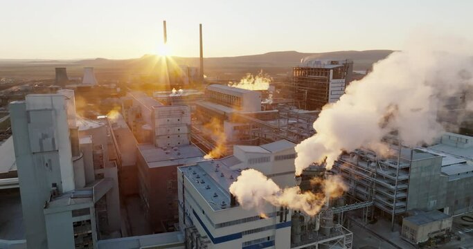 Iindustrial chemical plant with high pipes in bright light of winter sunset aerial view. SOLVEY SODI JSC Devnya, Bulgaria Synthetic soda ash production plant. Thick smoke comes from high pipe. Ecology