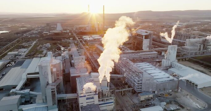 Iindustrial chemical plant with high pipes in bright light of winter sunset aerial view. SOLVEY SODI JSC Devnya, Bulgaria Synthetic soda ash production plant. Thick smoke comes from high pipe. Ecology