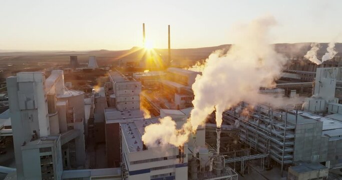 Iindustrial chemical plant with high pipes in bright light of winter sunset aerial view. SOLVEY SODI JSC Devnya, Bulgaria Synthetic soda ash production plant. Thick smoke comes from high pipe. Ecology