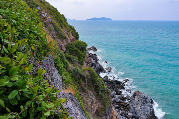 high-angle landscape of rocks by the sea The view from the mountain in the island with the cool breeze, green trees and the blue sea. The air is nice and refreshing in the summer in Thailand.
