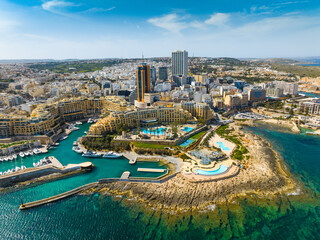 St. Julian's city and modern high buildings. Day, drone. Malta island