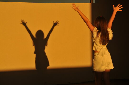 sombra de menina com braços erguidos para liberdade 