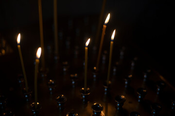 Candles in Church. Candles in Orthodox Church. Lights in dark. Religious rite.