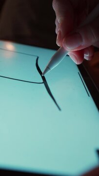 Close up young woman working and drawing with stylus pc pen diagrams in evening home alone