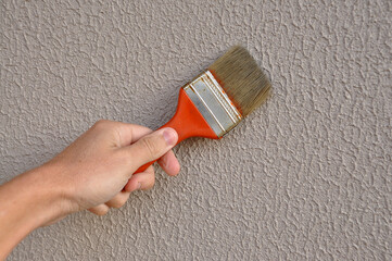 pintor segurando pincel pintando parede 