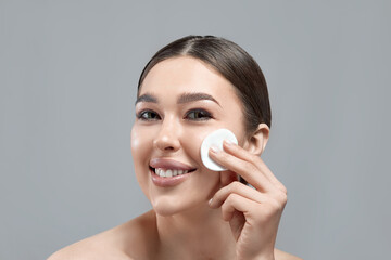 Woman Cleaning Face With White Pad. Beautiful Girl Removing Makeup White Cosmetic Cotton Pad. Happy Smiling Female Taking Off Makeup From Facial Skin With Cosmetic Pad. Face Skin Care.