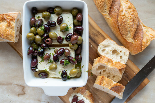 Marinated black and green olives with oven baked feta cheese and baguette - Powered by Adobe