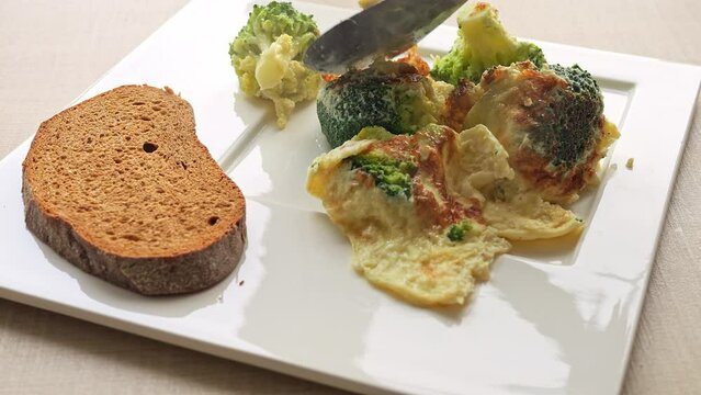 Scrumptious breakfast of omelette and broccoli beautifully presented on plate. Spatula gracefully serves meal. Enjoy nutritious breakfast featuring, ideal for wholesome breakfast to start your day.