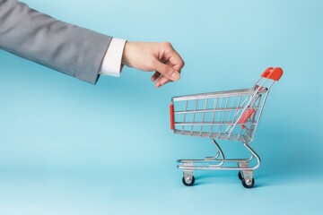 Businessman hand holding a shopping cart, concept of business and online store, online shopping.