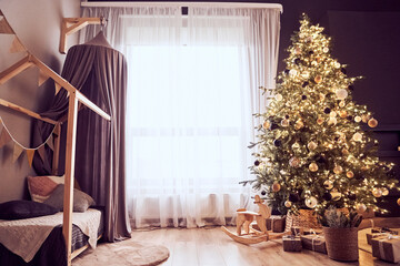 Christmas decor in domestic, cosy living room with christmas tree with lighting strings, wooden rocking chair, gifts, bed with canopy, party bunting flags. Background with copy space.