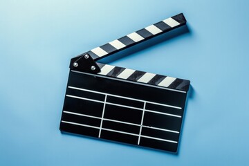 Fototapeta premium Person holding a cinema clapperboard, cinematographic production, blue background.