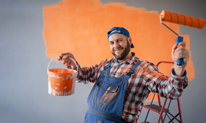 Renovation, redecoration and repair concept. Funny bearded man with painting roller and bucket...