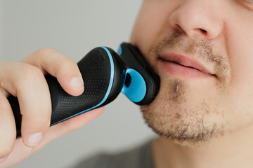 Man cuts his beard with a trimmer