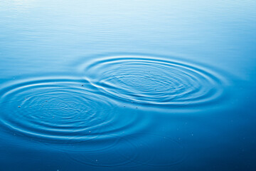 Round droplets of water over circles on the lake. Water drop, whirl and splash.Phone and laptop...