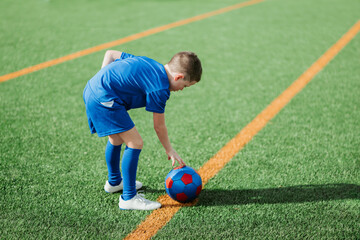 Young soccer player preparing for kickoff on field