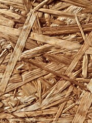 The pressed wood surface of sawdust close-up. The texture of the chipboard background. Recycling and reuse of wood