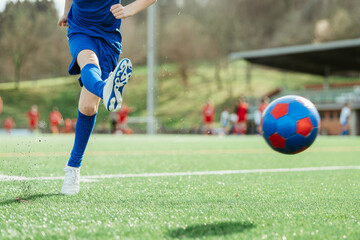 Soccer player kicking ball on a sunny day