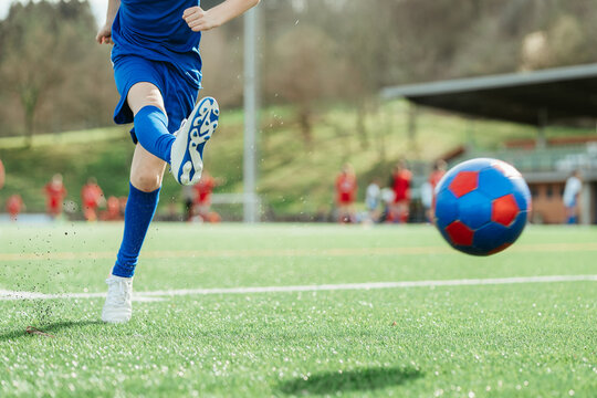 Soccer player kicking ball on a sunny day - Powered by Adobe