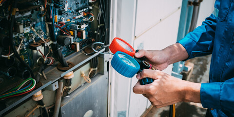 Technician is checking air conditioner refrigerant leak.