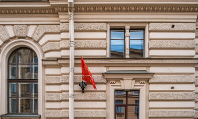 A red flag on the wall of a building in the city.