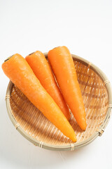 ザルにのった人参と白背景のフリースペース