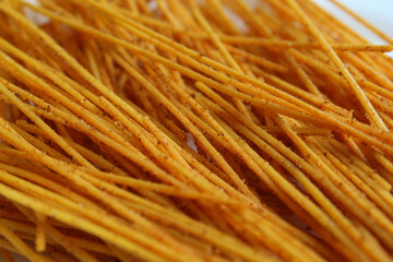 Background texture of Mie Lidi Pedas, traditional snack from Indonesia. Noodle-like texture, fried and coated with chili powder