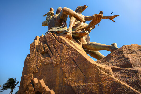 Dakar, Senegal - March 01, 2023 : Bronze statue called Monument of the African Renaissance under a blue sky.